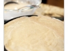 Crepes can be savory or sweet. Originally they come from Brittany in France but are now available anywhere. One crepe is being made in the foreground. There is a shallow depth of field.