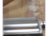Freshly made linguini are splitted by hand. The machine for making pasta is in the foreground (out of focus).