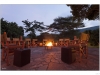 A row of chairs around a campfire.