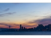 The Bay Bridge and the skyline of San Francisco at sunset.